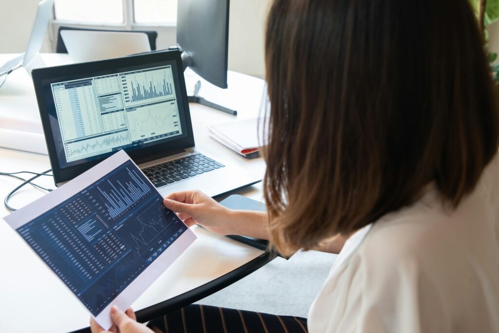 Building Trust and Engagement: Digital Marketing Strategies for the Modern Health Sector Healthcare professional analyzing digital marketing performance charts on a laptop and printed report.